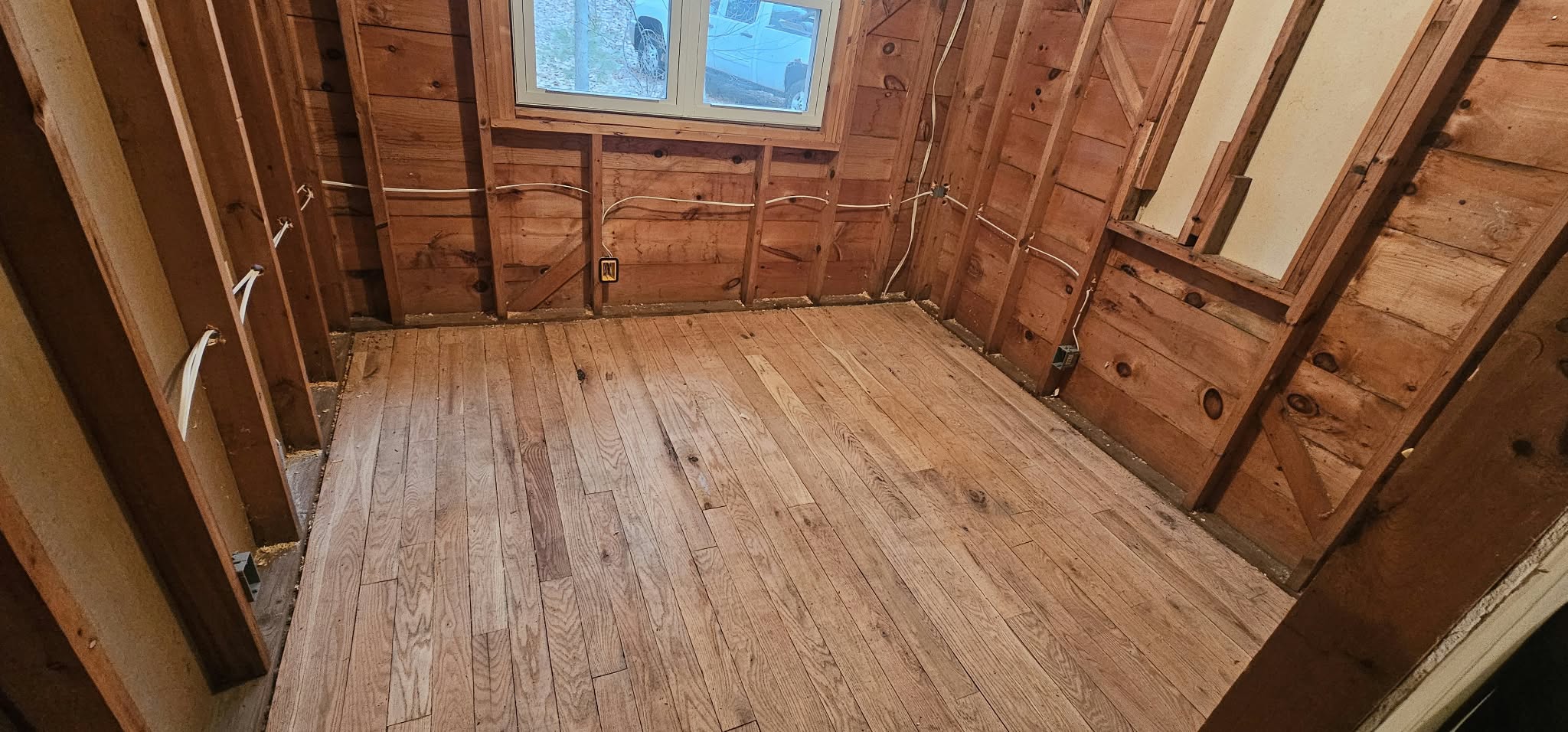 Before — stripped to studs, exposed framing and old electrical