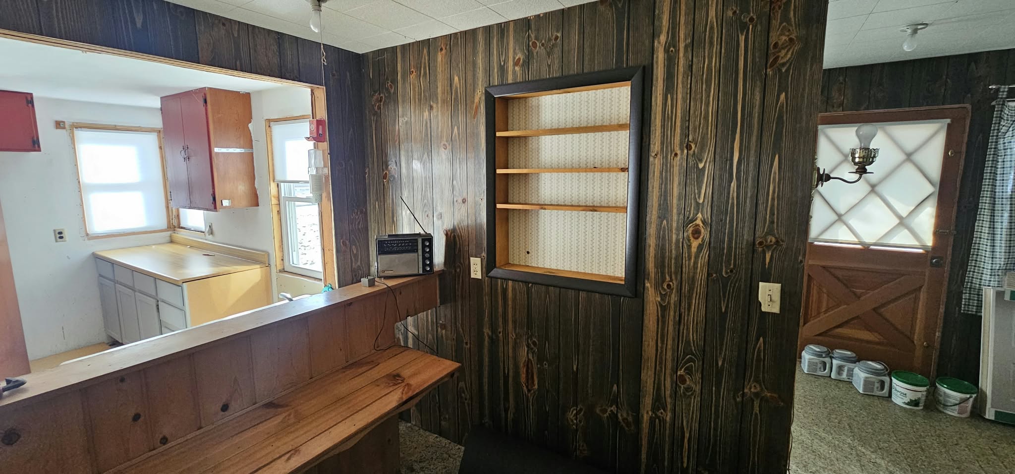 Before — original kitchen, dark wood paneling and old appliances