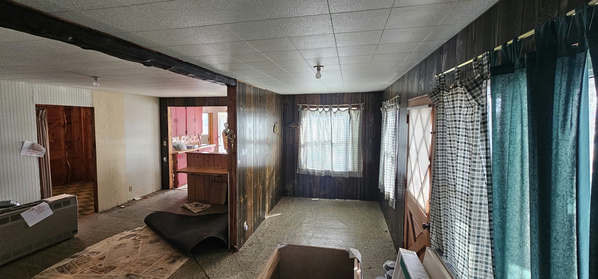 Before — living room alternate angle, dark paneling and old curtains