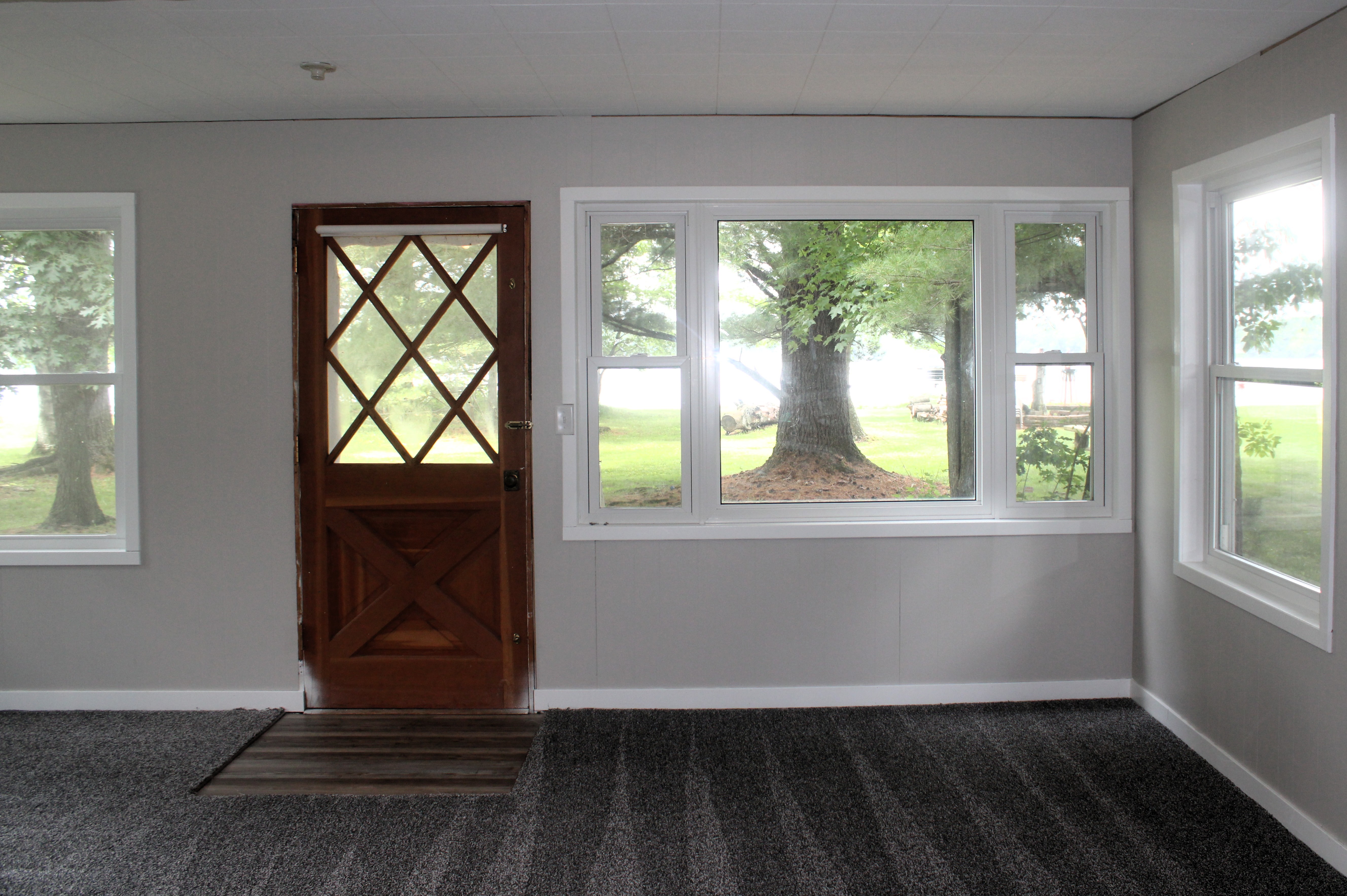 After — living room with original diamond-pane entry door and picture window